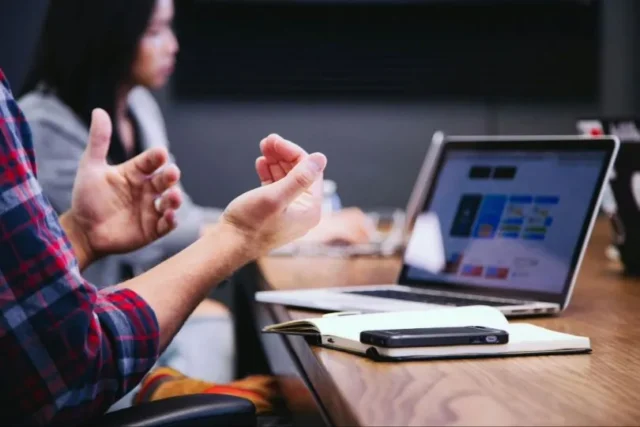 Man makes gesture in front of screen while using recruitment automation