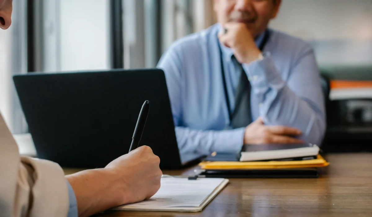 recruiting personnel writing down notes while listening to a job candidate