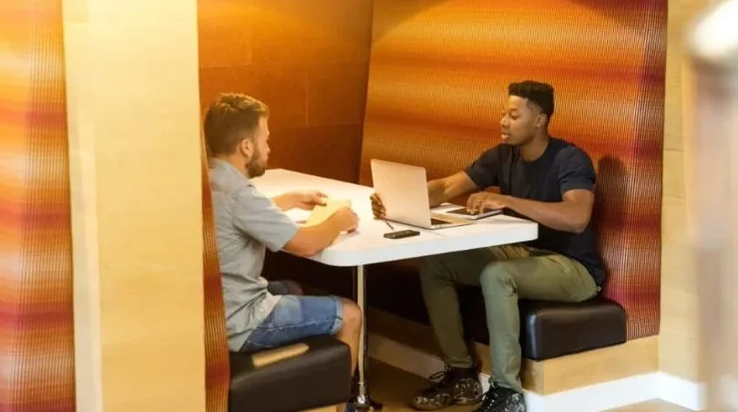 Informal job interview taking place between two men in a relaxed office setting