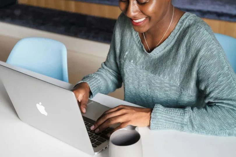 Smiling woman looking at candidate database on laptop