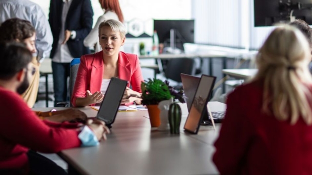Manager discussing about work with his coworkers in modern office