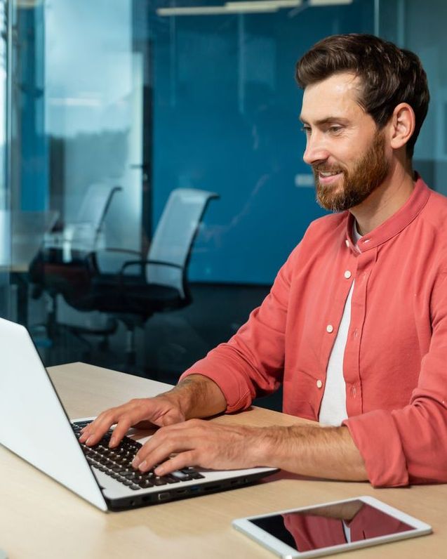 A professional working on a laptop in a meeting room.